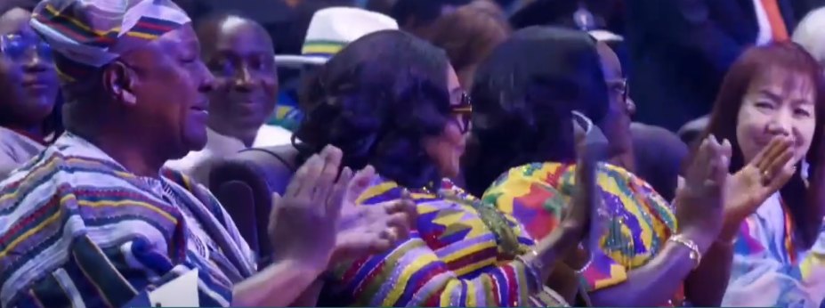 Guests in colourful kente applaud during the opening rally of the congress at the Accra Sports Stadium